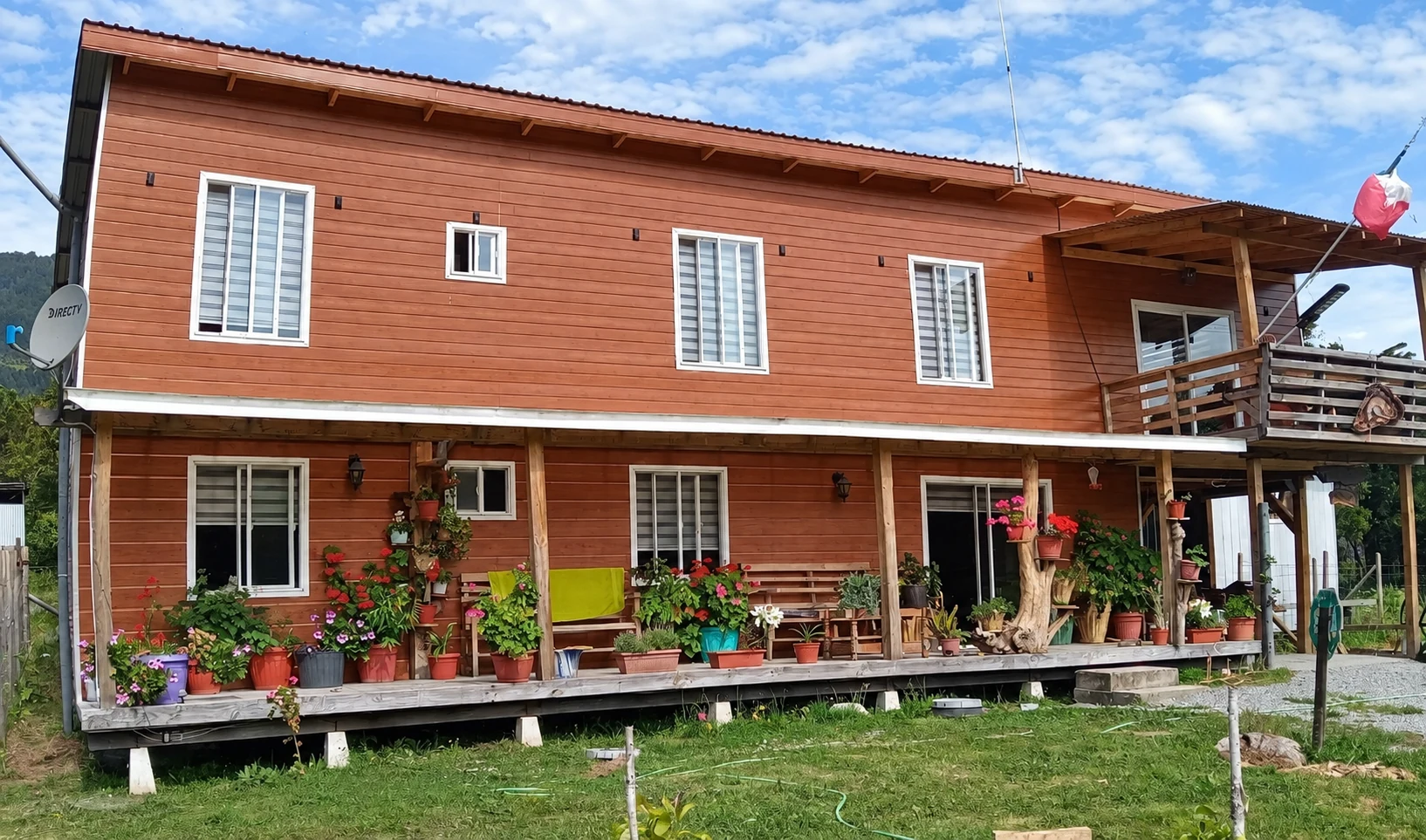 Fachada de dos pisos de Hospedaje Katya, con corredor y macetas con flores